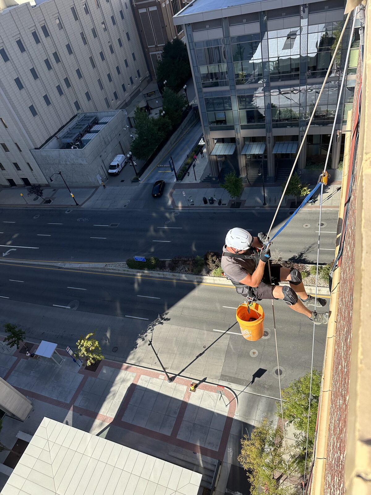 Technician on ropes above a commercial building exterior