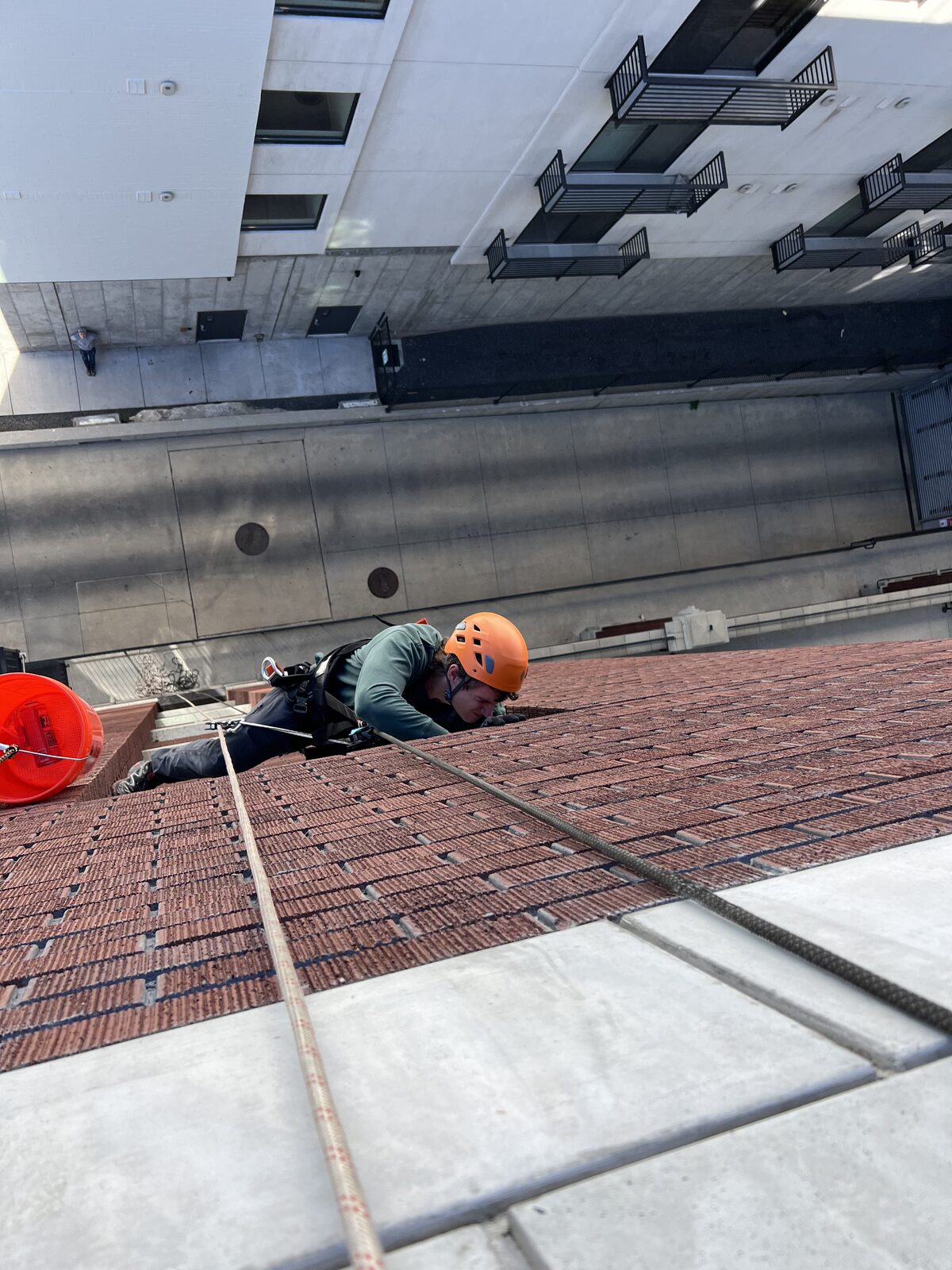 Rope-access technician inspecting a brick multistory building